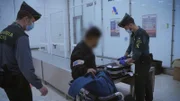 Grenzbeamte kontrollieren den Koffer.