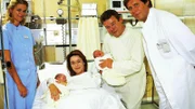 Dr. Frank (Sigmar Solbach, re.) beglückwünscht die Eltern Frau und Herrn Steigner (Constanze Roeder und Werner Asam) zu den gesunden Zwillingen. (Links: Claudia Lösel als Krankenschwester Susi)