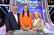 Quizmasterin Esther Sedlaczek (M.) mit den Kandidat:innen des Teams "Oranje": Harry Wijnvoord (l.), Moderator und Marijke Amado (r.), Moderatorin.