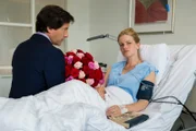 Mit einem Strauß Rosen bittet Erik Viklund (Christof Arnold, links) Julia Bergen (Mira Bartuscheck, rechts) am Krankenbett um Verzeihung.