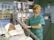 Holger Krauss liegt auf der Intensivstation. Die zweite Operation konnte noch nicht durchgeführt werden, da sich seine Ex-Frau gegen die Operation ausgesprochen hat. Holger Krauss (Frank Behnke) und Dr. Kathrin Globisch (Andrea Kathrin Loewig).