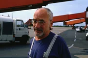 Überall auf dem Rollfeld sucht Peter (Peter Lustig) seinen Koffer. Vielleicht ist er ja vom Gepäckwagen gefallen und liegt irgendwo im Flughafengelände.