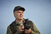 Simone Duke (Jason Watkins) fotografiert rund ums Safe House.