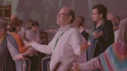 Inmitten eines spirituellen Festivals: ein Teilnehmer, der durch Meditation zum Glück finden will.