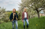 Frieda (Therese Hämer,l.) und Elli (Frida-Lovisa Hamann, r.) stehen in einer Obstplantage.