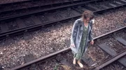 Eine Frau steht auf den Bahngleisen