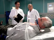 Wilhelm Mehnert (Sky du Mont, liegend) hat die Sachsenklinik gegen den strikten Rat seiner beiden behandelnden Ärzte Prof. Simoni (Dieter Bellmann, re.) und Dr. Philipp Brentano (Thomas Koch, li.) verlassen. Nach wie vor sind sich die beiden Ärzte bei ihren Diagnosen nicht einig. Doch Prof. Simoni will Wilhelm jetzt operieren!