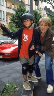 Nikola (Mariele Millowitsch) versucht Hermann (Nikita Wokurka) beizubringen, wie man Skateboard fährt.