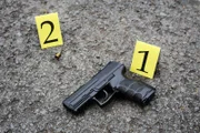 outdoor crime scene investigation. black pistol and marks