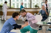 Der 25-jährige Vincent Tülke (Antonije Stankovic, r.) bekommt einen Krampfanfall. Florian Osterwald (Lion Wasczyk, l.) eilt zur Hilfe (mit Kopars:innen, h.).