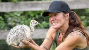 Kerstin Schnabel mit einem Straußen-Küken in der Hand.
