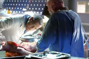Dr. Raymond Langston (Laurence Fishburne, l.) und Dr. Robbins (Robert David Hall) untersuchen den Körper des Opfers.