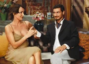 Schöni Uussichte Motivación verleiht Flügel - Sitcom Staffel 2, Episode 4 Kiki ist ganz Geschäftsfrau gegenüber Miklas:: «Bevor wir die Verträge unterzeichnen, müssen Sie an 'Kiki Number One' riechen!» - Anouschka Renzi als Kiki, Salvatore Greco als Miklas Skarlakidis