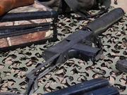Eine fies aussehende MAC-10 sitzt auf einem Tarnnetz.