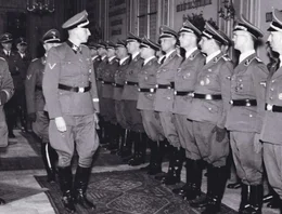 F&uuml;r die Nazis der perfekte Nationalsozialist: SS Obergruppenf&uuml;hrer Reinhard Heydrich (l., 1904-1942), Chef der Sicherheitspolizei und des Sicherheitsdienstes, hier bei einem Besuch einer Polizeischule in Prag 1942, sa&szlig; der Wannseekonferenz am 20.01.1942 vor.