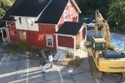 A house is about to be destroyed by workers.