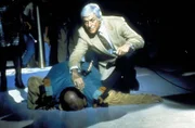 Buddy Blake (Tom DeLuise, l.) stürzt mit einem Messer im Rücken zu Boden. Dr. Sloan (Dick Van Dyke, r.) eilt ihm sofort zu Hilfe.