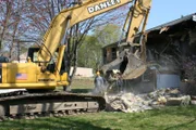 Amesbury, MA, USA: Kip Walker in seinem Bagger beim Abriss des abgebrannten Hauses.