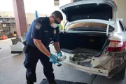 CBP-Beamter Salcido hält ein Paket mit mutmaßlichen Betäubungsmitteln, das in der hinteren Stoßstange des Fahrzeugs eines Verdächtigen in El Paso, Texas, entdeckt wurde. (National Geographic)