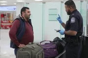 Der CBP-Beamte De La Cruz befragt einen Reisenden, während er dessen Gepäck am Philadelphia International Airport in Philadelphia, Pennsylvania, kontrolliert.