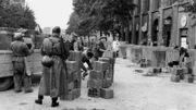 Mauerbau in Berlin, 18.08.1961. Fünf Tage nach Beginn des Mauerbaus wird die Sperrlinie zwischen Berlin-Ost und Berlin-West weiter ausgebaut. Hier verlängern Maurer und Hilfskräfte unter der Aufsicht eines Bewaffneten die Mauer in Richtung Lindenstraße.
