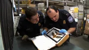 JFK Airport, Jamaica, NY: CBP Officers Marty Chiani (left) and Tony Condello (right) inspect a package with bats in it.