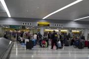 Mehrere Reisende warten an der Gepäckausgabe des JFK International Airport in New York auf ihr Gepäck.