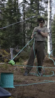 Alex Javor benutzt Seile und Flaschenzüge, um Holzstämme einen Berg hinaufzuführen (National Geographic/Josh Fisch).