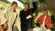 Dr. Stefan Frank (Sigmar Solbach, M.) versorgt den angeschossenen Tankstellenbesitzer Bachmann im Notarztwagen. Beate Bachmann (Angela Hobrig, l.) bleibt an der Seite ihres Mannes.