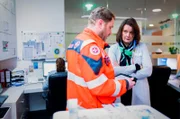 Eine Reportage von Katrin Wegner, Ein Notfallsanitäter übergibt einen Patienten an Dr. Barbara Jost.
