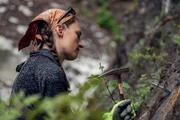 Kayla Johanson hält einen Hammer, um Schrauben in einer Bergwand zu befestigen.