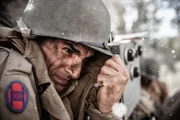REENACTMENT- U.S. Sergeant Ammon Sasser geht in Deckung, nachdem eine deutsche Granate weißen Phosphor verstreut hat. Gespielt von: Kevin Trumble.