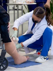 Nahaufnahme von Dr. Sandra Lee, die das von Paula W. befallene linke Bein einwickelt.