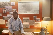Investigator Dennis Jones (played by Glen Michael Grant) analyzes photos of the crash site and schematics to find out what happened to downed LAM Mozambique Flight 470.