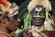 Papua-Neuguinea, Westprovinz: Zwei Mitglieder des Biami-Stammes im Dorf Negadai bereiten sich auf ein Festmahl mit Schwein vor.