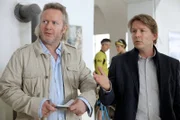 Oberstleutnant Helmuth Nowak (Gregor Seberg, l.) befragt den Inhaber des Fahrradbotendienstes Lorenz Wallner (Serge Falck, r.) nach dem ermordeten Fahrradboten. Im Hintergrund unterhalten sich die Angestellten Simon (Stefan Pohl) und Elisabeth Acker (Sophie Pfenningstorf).
