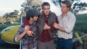 Alberto (Ben Mortley, l.) und Nick (Brett Tucker, r.) helfen dem verletzten Alex (Aaron Jeffery) auf die Beine.