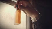 Close-up of hand holding up bottle of whiskey. (National Geographic/Alex Macdonald)