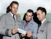 L-R: Piloten E.J. Smith, Kenneth Arnold und Ralph E. Stevens sehen sich ein Foto eines nicht identifizierten Flugobjekts an, das sie auf dem Weg nach Seattle, Washington, gesehen haben.