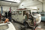 Westgate Classics, Walsall, UK - Mechanics Jan Stein and Stefan Stein sand down the bodywork of the VW Camper during the restoration.