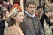 Bei der Aufführung des Theaterstücks, in dem zur großen Belustigung des Volkes der Papst und der Klerus verunglimpft werden, kommt es zu einem Eklat zwischen Anne und Brandon (Henry Cavill, r.), der von Henry beauftragt wird, den Admiral de France gemeinsam mit seiner Frau (Darstellerin unbekannt, l.) zu empfangen ...