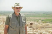 Professor Steven Collins am Ausgrabungsort in Tall-El-Hammam, wo er die Aschenschicht betrachtet, in der er menschliche Überreste, Steine, Ziegel und Töpferwaren gefunden hat.