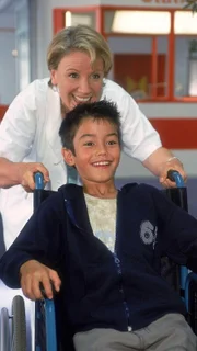 Da kann der Kleine wieder lachen: Um Hermann (Nikita Wokurka) aufzuheitern, dreht Nikola (Mariele Millowitsch) mit ihm schnell eine Runde im Rollstuhl über den Krankenhausflur...