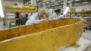Members of the conservation team at the Grand Egyptian Museum work on restoring Tutankhamun's golden coffin.