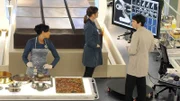 Cam (Tamara Taylor, l.), Brennan (Emily Deschanel) und Vincent Nigel-Murray (Ryan Cartwright) untersuchen die sterblichen Überreste einer Frau, die in einer ausgestellten Riesenschokolade einer Schokoladenfabrik gefunden wurde.