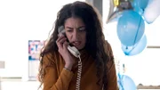 Eine verängstigte Frau spricht in ihr Festnetztelefon