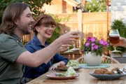 Mary und Aaron stoßen zum Essen an.