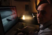 Rom, Italien - Silvano Vinceti (Mitwirkender) - Vinceti's studio - Betrachtung der hochauflösenden Bilder von Mona Lisa und Silvano bei der Besprechung seiner Erkenntnisse über die Buchstaben in Mona Lisas Augen bzw. die Zahl unter der Brücke.