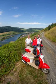 Die Praktikanten Alexandra Stockerl und Sebastian Lachnitt machen einen Ausflug mit der Vespa durch die Weinberge.