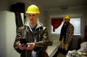 Ringo Holländer (Tim Kalkhof, l.) sucht in der Unterkunft eines Mandanten, dem Diebstahl auf einer Großbaustelle vorgeworfen wird, nach entlastenden Beweisen; Liviu Bunesco (Jörg Steinberg, r.), ein Kollege, gibt sich ahnungslos.